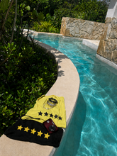 Load image into Gallery viewer, Golden hour and Midnight ribbed vests with star design and red camera on poolside ledge
